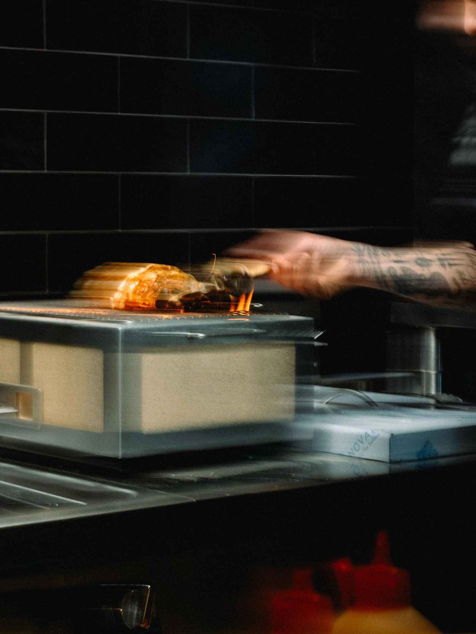 Een kok legt brood op de houtskoolgrill in de open keuken